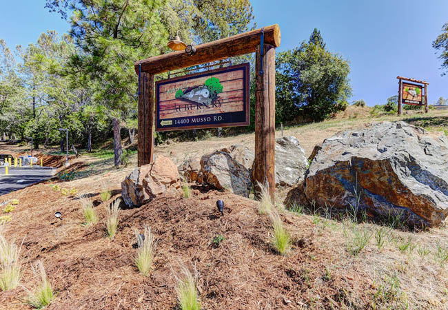 Rustic wooden welcome sign at Auburn RV Resort entrance